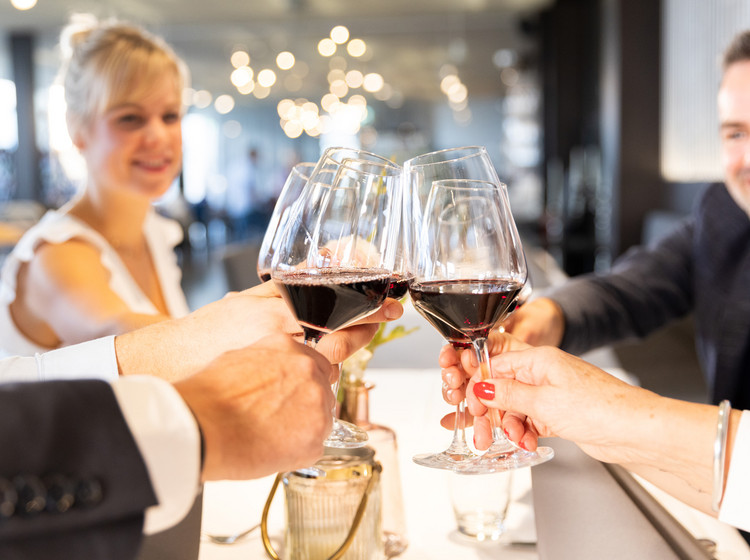 Gäste stoßen mit Weingläsern im DO-X Restaurant Friedrichshafen an