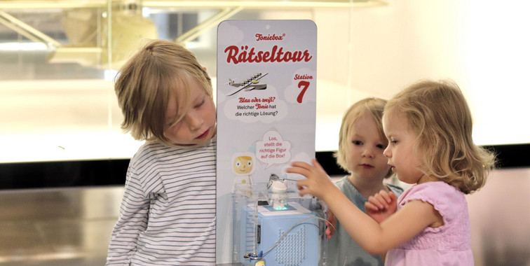Drei Kinder spielen mit Toniebox
