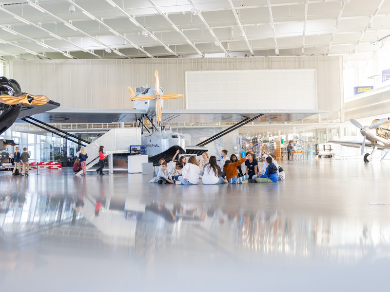 Der Hangar mit einer Schulklasse im Hintergrund.