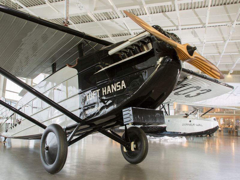 Originalflugzeug aus der Frühzeit der Luftfahrt mit sichtbarem Gerüst und Stoffbespannung in der Ausstellung des Dornier Museums