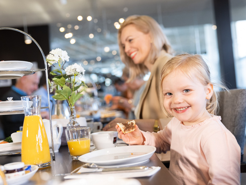 Eine Mutter mit ihrem Kind genießt ein entspanntes Frühstück im Dornier Museum.ine Mutter mit ihrem Kind genießt ein entspanntes Frühstück im Dornier Museum.