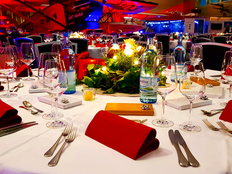 Ein festlich gedeckter Tisch für eine Weihnachtsfeier im Hangar.
