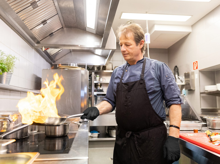 Koch kocht in der Küche des DO-X Restaurants